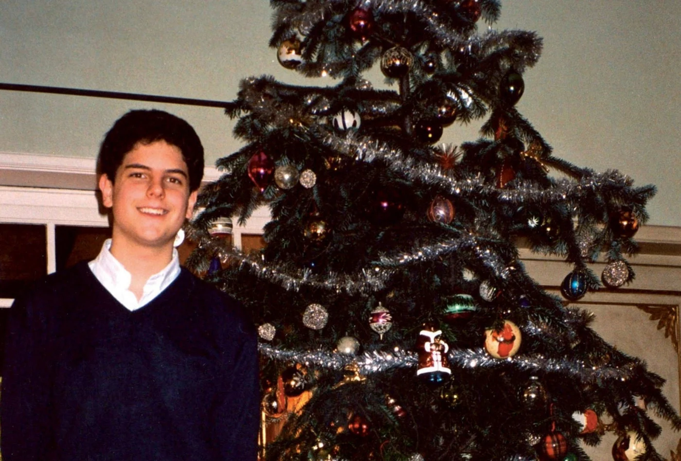 Carlo Acutis junto a un árbol de Navidad